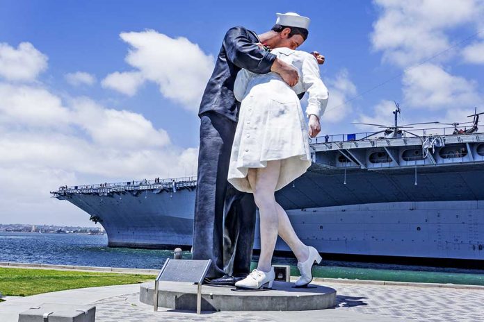 Statue of a sailor kissing a nurse, waterside backdrop.