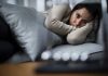 Person lying on couch looking thoughtful and somber