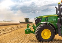 A green tractor in a wheat field.