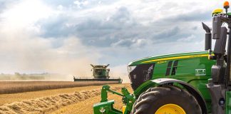 A green tractor in a wheat field.