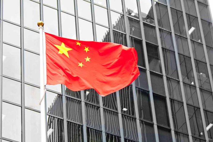 Chinese flag waving in front of glass building