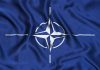 NATO flag with blue background and white compass.