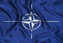 NATO flag with blue background and white compass.