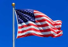 United States flag waving against blue sky
