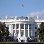 White House with American flag flying, daytime