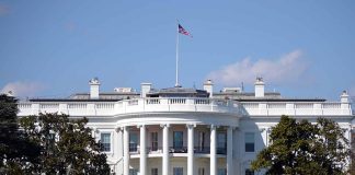 White House with American flag flying, daytime