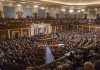 Audience in a large hall with central podium