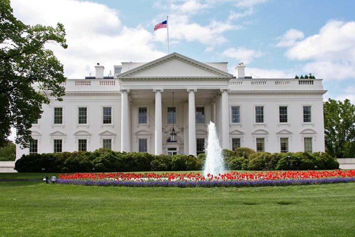 White building with fountain and flower garden front