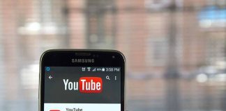 Hand holding smartphone with YouTube app open