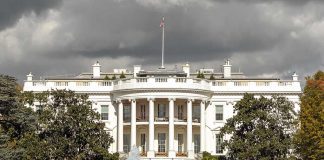 The White House with overcast sky and flag raised.