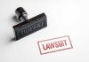 Rubber stamp with lawsuit text on paper