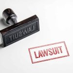 Rubber stamp with lawsuit text on paper
