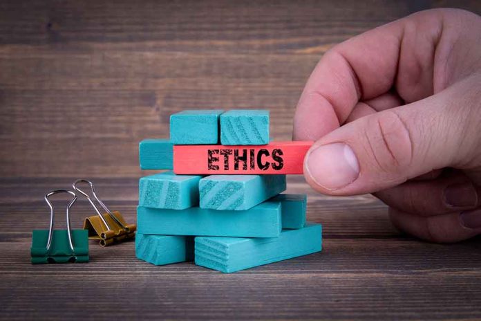 1108182914 featured image Hand holding red block labeled ethics above blue blocks.