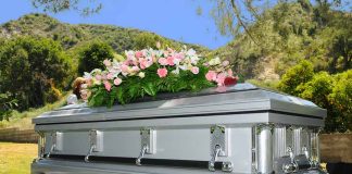 Silver casket with flowers at outdoor funeral