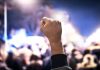 Raised fist in a crowd at night