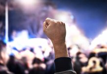Raised fist in a crowd at night
