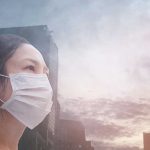 Person wearing a mask in a cityscape background