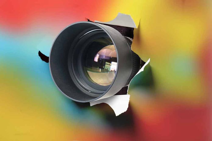 1892209375 featured image Camera lens poking through torn colorful background