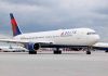 Delta Airlines airplane on airport runway cloudy sky