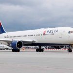 Delta Airlines airplane on airport runway cloudy sky