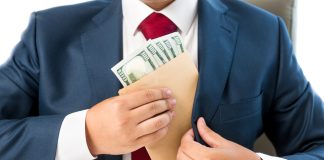 Person placing envelope with cash into suit pocket