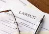 Lawsuit papers with glasses and pen on table