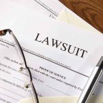 Lawsuit papers with glasses and pen on table