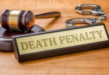 Gavel handcuffs and death penalty sign on table