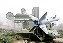 Military missile launcher with radar systems in a foggy field