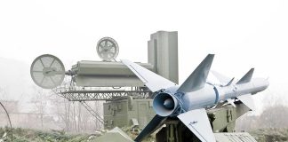 Military missile launcher with radar systems in a foggy field