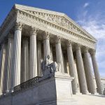 Supreme Court building with columns and statue in front