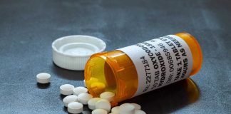 Prescription bottle with pills spilled on table