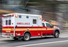 Red and white ambulance driving on street