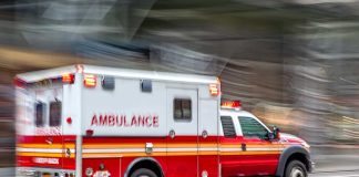 Red and white ambulance driving on street
