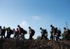 Line of people walking with backpacks outdoors
