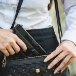 Person placing gun into a handbag