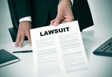 Person holding a document titled LAWSUIT in office