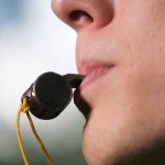 Person holding a whistle in their mouth