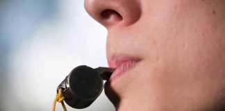 Person holding a whistle in their mouth