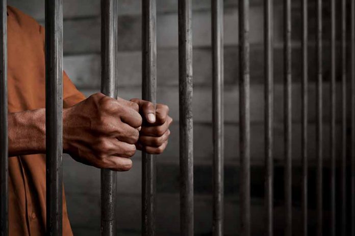 772489252 featured image Hands gripping prison cell bars