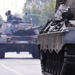 Tanks on a road with soldiers inside