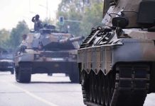Tanks on a road with soldiers inside