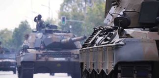 Tanks on a road with soldiers inside