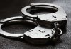 Close up of metal handcuffs on a dark surface