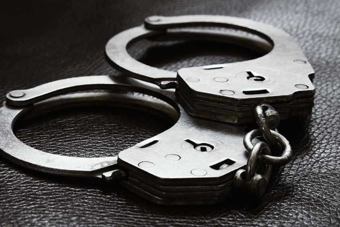 Close up of metal handcuffs on a dark surface
