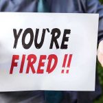 Person holding YOU ARE FIRED sign