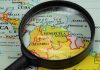 Magnifying glass focusing on Venezuela and Colombia on map