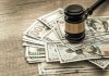 Gavel on a pile of hundred-dollar bills