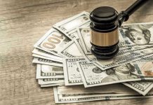 Gavel on a pile of hundred-dollar bills