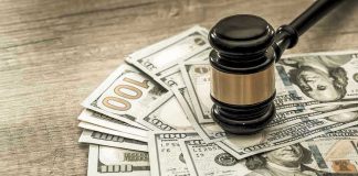 Gavel on a pile of hundred-dollar bills